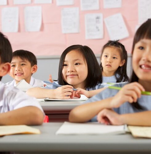 Group Of Students Working At Desks In Chinese School Classroom_MathArchery